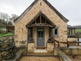 An entrance of a stone house with a wooden door at Spring View, Tetbury