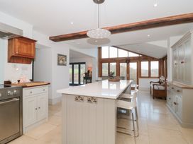 A kitchen with an island and stools at Spring View in Kingscote, Gloucestershire