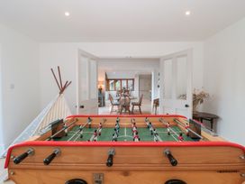 A foosball table with a view into the dining area at Spring View in Kingscote, Gloucestershire