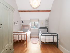 A bedroom with two beds and a window at Spring View in Kingscote, Gloucestershire