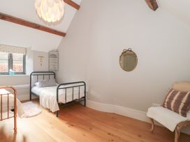 A bedroom with two beds and a mirror at Spring View, Kingscote, Gloucestershire