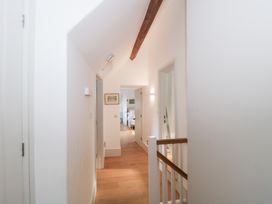 A hallway with doors and a wooden beam at Spring View in Kingscote, Gloucestershire