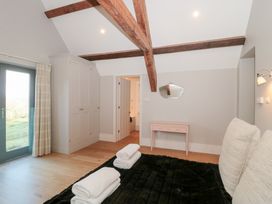 A bedroom with a bed and a wardrobe at Spring View in Kingscote, Gloucestershire
