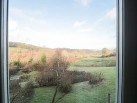 A view of a green landscape with trees from a window at Spring View, Kingscote, Gloucestershire