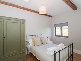 A bedroom with a bed and wardrobe at Spring View in Kingscote, Gloucestershire