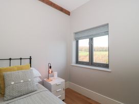 A bedroom with a bed and a window at Spring View in Kingscote, Gloucestershire