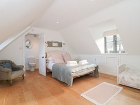 A bedroom with a bed and a chair at Spring View in Kingscote, Gloucestershire