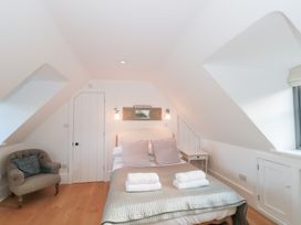 A bedroom with a bed and side table at Spring View in Kingscote, Gloucestershire