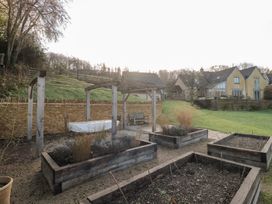 A garden with raised beds and a bench at Spring View in Kingscote, Gloucestershire