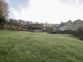 A garden with a house and garage at Spring View in Kingscote, Gloucestershire