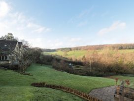A garden with a house and a landscape view at Spring View, Kingscote, Gloucestershire