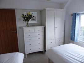 A bedroom with a dresser and wardrobe at Gilfach Goed in Pwllheli