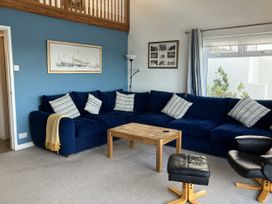 A living room with a blue sofa and coffee table at Gilfach Goed in Abersoch