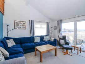 A living room with a blue sofa and coffee table at Gilfach Goed in Abersoch