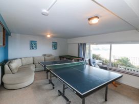 A game room with a table tennis table and couch at Gilfach Goed in Abersoch