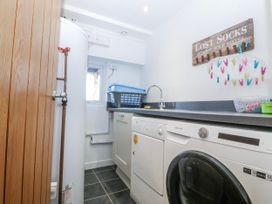 A laundry room with a washing machine and sink at Gilfach Goed in Abersoch