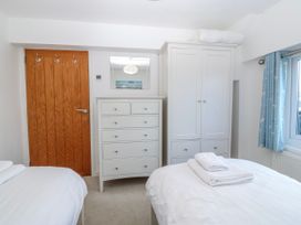 A bedroom with two beds and furniture at Gilfach Goed Abersoch