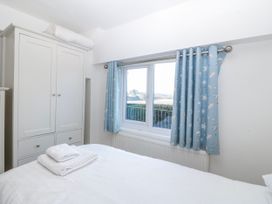 A bedroom with a bed and wardrobe at Gilfach Goed in Abersoch