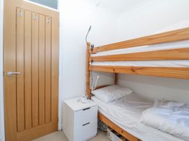 A bedroom with a bunk bed and a bedside table at Gilfach Goed in Abersoch