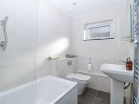 A bathroom with a bath, toilet, and sink at Gilfach Goed in Abersoch