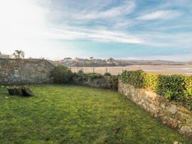 A garden with stone walls and grass at Gilfach Goed Abersoch