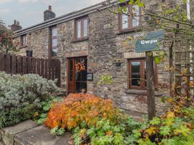 Stone building with plants and sign at Gwyn Studio in Aberdare