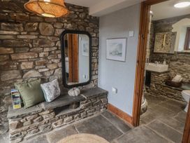 A bathroom with a mirror, bench, and a sink at Gwyn Studio in Aberdare