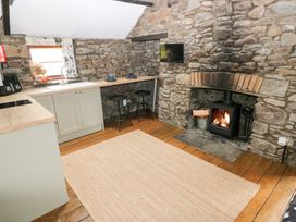 A kitchen with a fireplace and barstools at Glas Studio in Aberdare