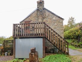 A stone building with a wooden staircase at Glas Studio in Aberdare