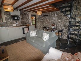 A living room with a sofa and kitchenette at Arian in Aberdare
