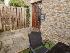 An outdoor space with a stone wall and a wooden fence at Arian in Aberdare