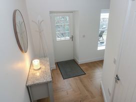 An entryway with a mirror and a coat stand at Awelfryn