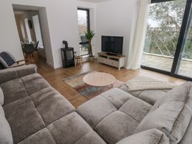A living room with a sofa, coffee table, and television at Awelfryn