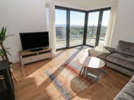 A living room with a TV and sofa at Awelfryn 
