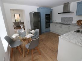 A kitchen with a dining table and chairs at Awelfryn