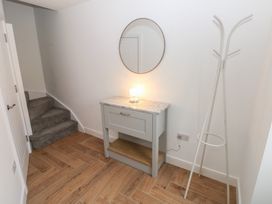 A hallway with a console table and stairs at Awelfryn 
