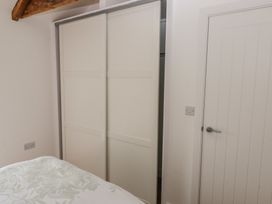 A bedroom with a wardrobe and door at Awelfryn 