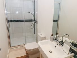 A bathroom with shower, toilet, sink and mirror at Awelfryn