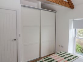 A bedroom with a sliding wardrobe and window at Awelfryn in 