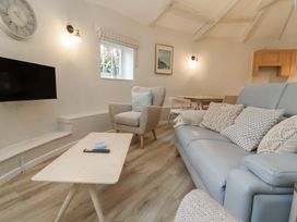 A living room with a television and seating area at Round Barn in Ilfracombe