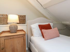 A bedroom with a bed and bedside lamp at Round Barn in Ilfracombe