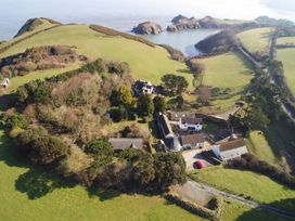 An aerial view of a property surrounded by greenery and water at Round Barn in Ilfracombe