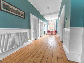 A hallway with wooden flooring and a chair at 8 Corkickle Whitehaven
