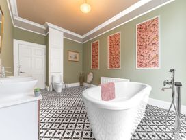 A bathroom with a bath tub, toilet, sink, and wall art at 8 Corkickle in Whitehaven