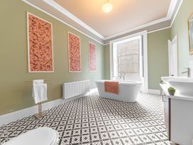 A bathroom with a bathtub, sink, and towel rack at 8 Corkickle Whitehaven