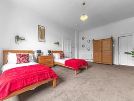 A bedroom with two beds and furniture at 8 Corkickle in Whitehaven