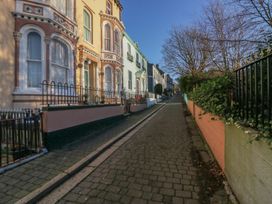 A street with colorful buildings and trees at 8 Corkickle, Whitehaven