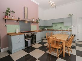 A kitchen with cooking appliances and dining table at 8 Corkickle in Whitehaven