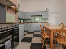 A kitchen with cabinets and a dining table at 8 Corkickle Whitehaven