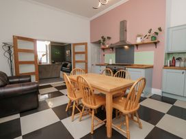 A kitchen with a wooden table and chairs at 8 Corkickle Whitehaven